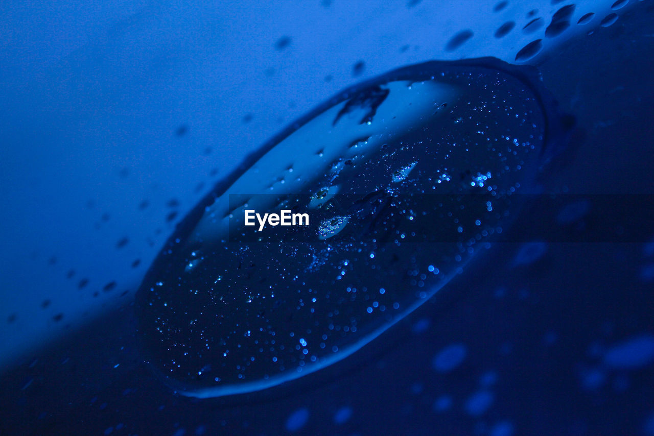 CLOSE-UP OF WATER DROPS ON GLASS OF CAR