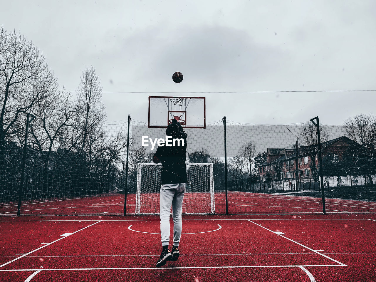 Rear view of man standing on pole against basketball 