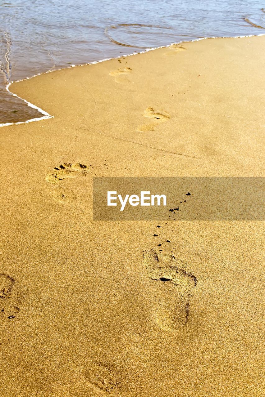 HIGH ANGLE VIEW OF FOOTPRINTS ON SHORE