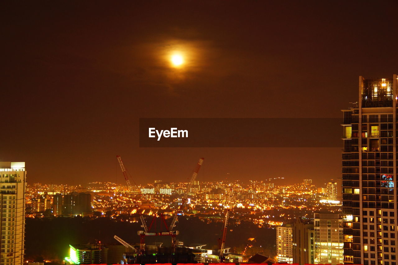 ILLUMINATED CITYSCAPE AGAINST SKY AT NIGHT