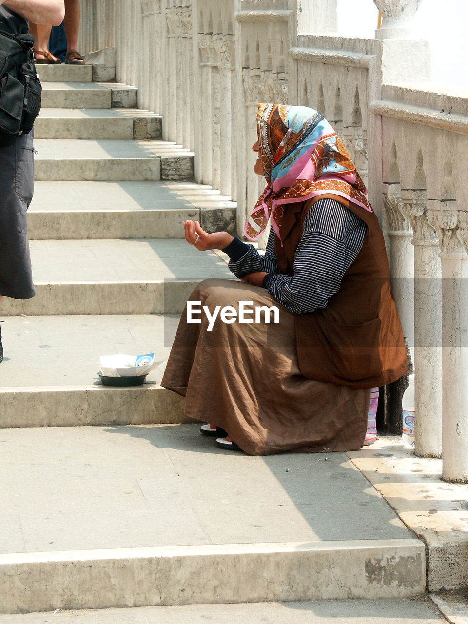 PEOPLE SITTING ON STAIRCASE BY BUILDING