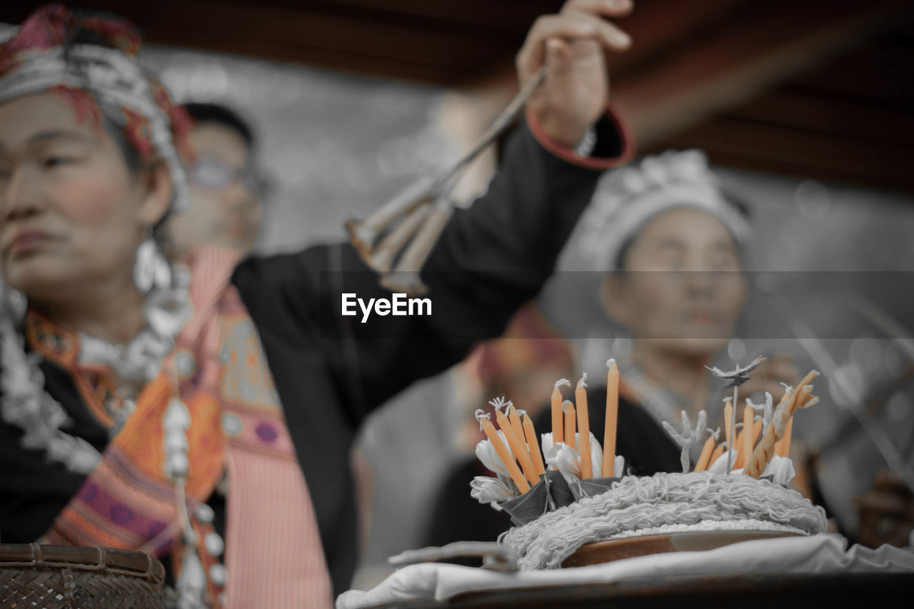 Low angle view of candles with woman in background