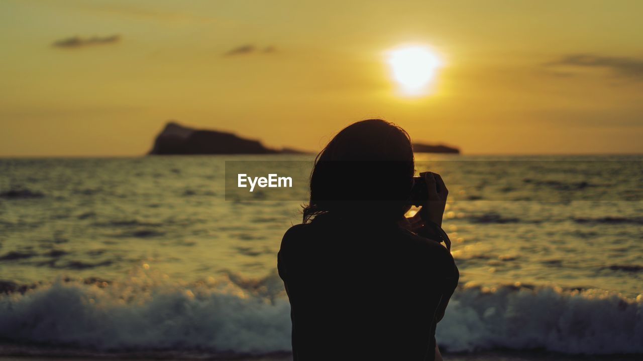 Silhouette woman at beach during sunset