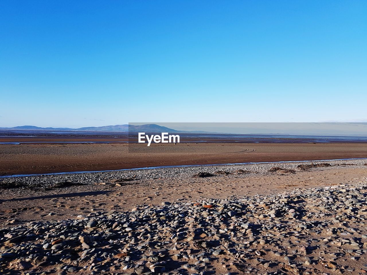 SCENIC VIEW OF SAND DUNE AGAINST CLEAR SKY