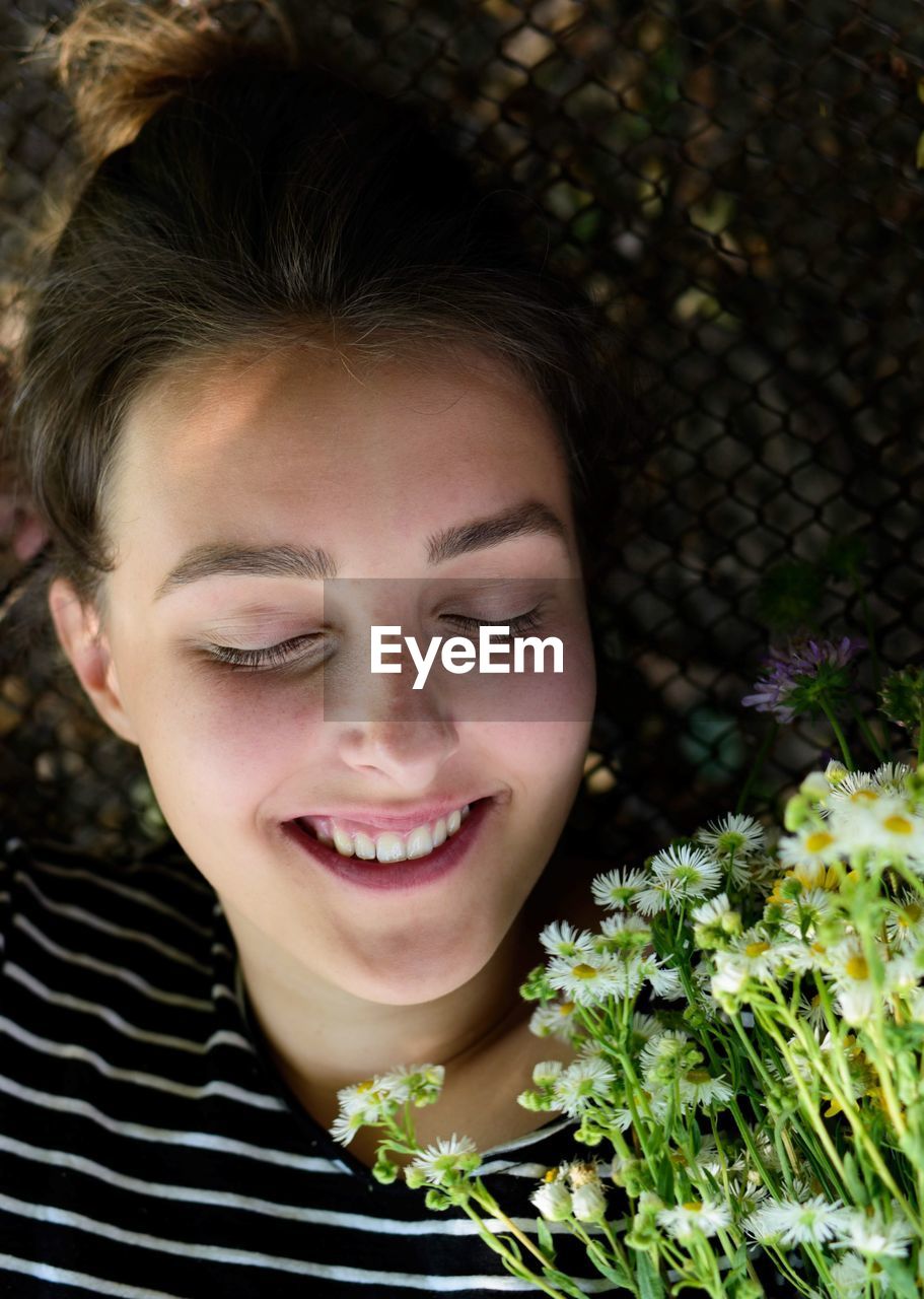 High angle view of smiling teenage girl with flowers