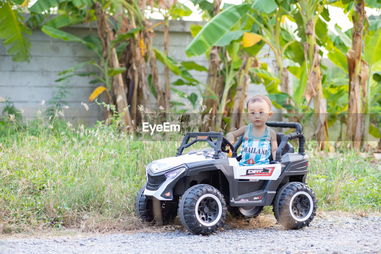 PORTRAIT OF BOY AND CAR