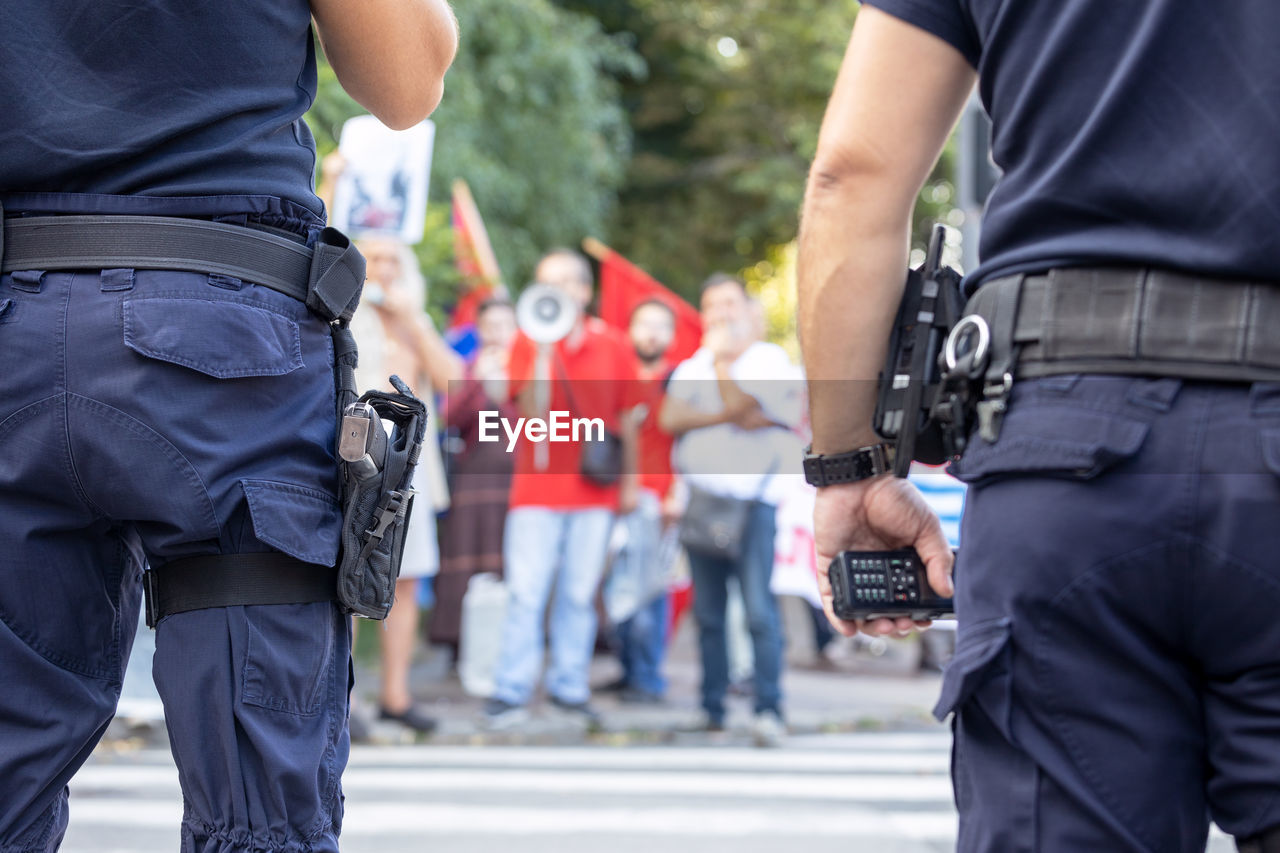 Police on duty during street protest, blurred protester in the background