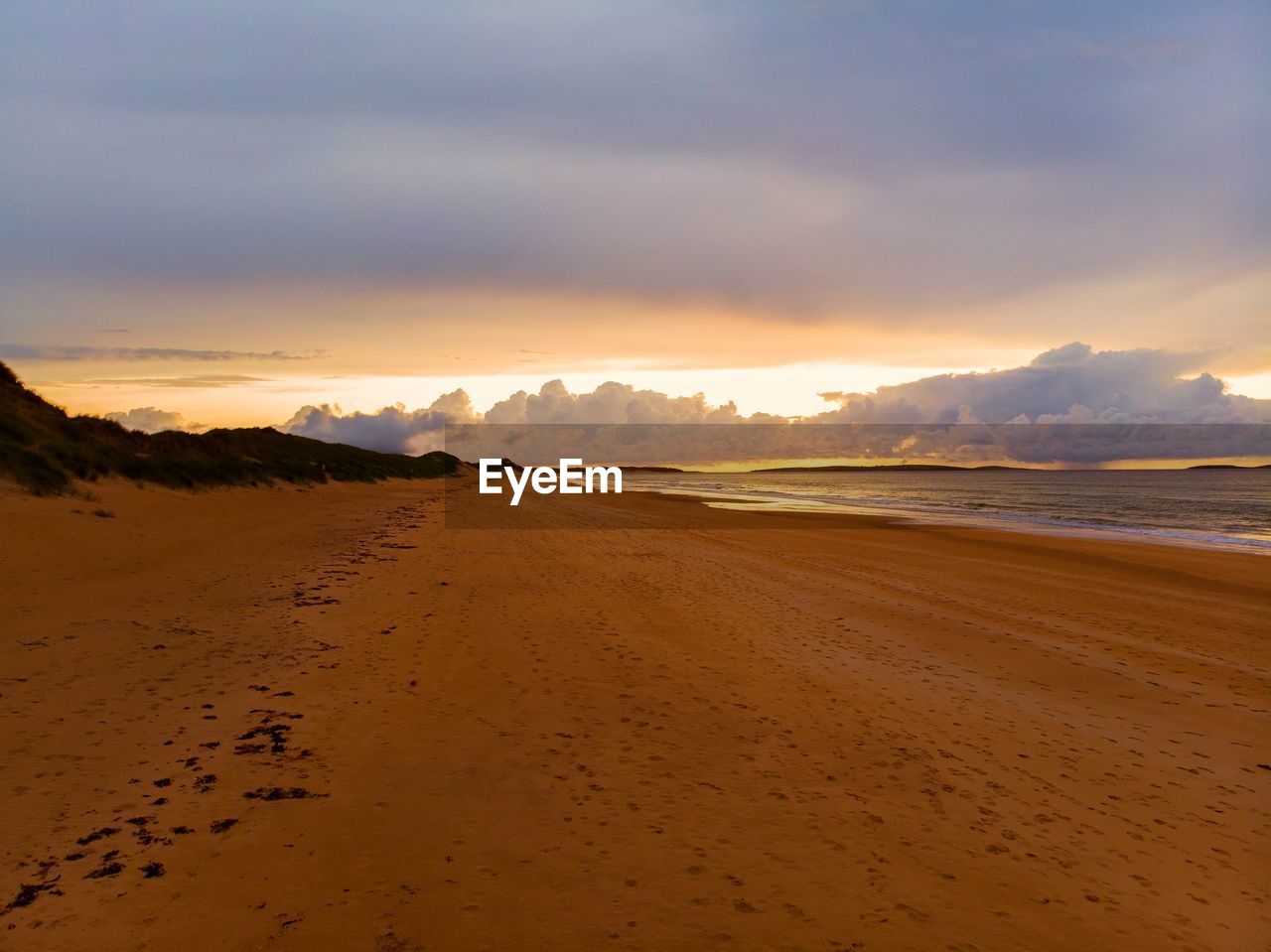 Scenic view of beach against sky during sunset