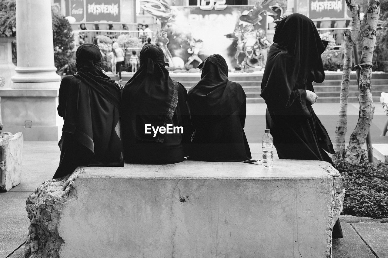 Women in burka sitting on abandoned seat