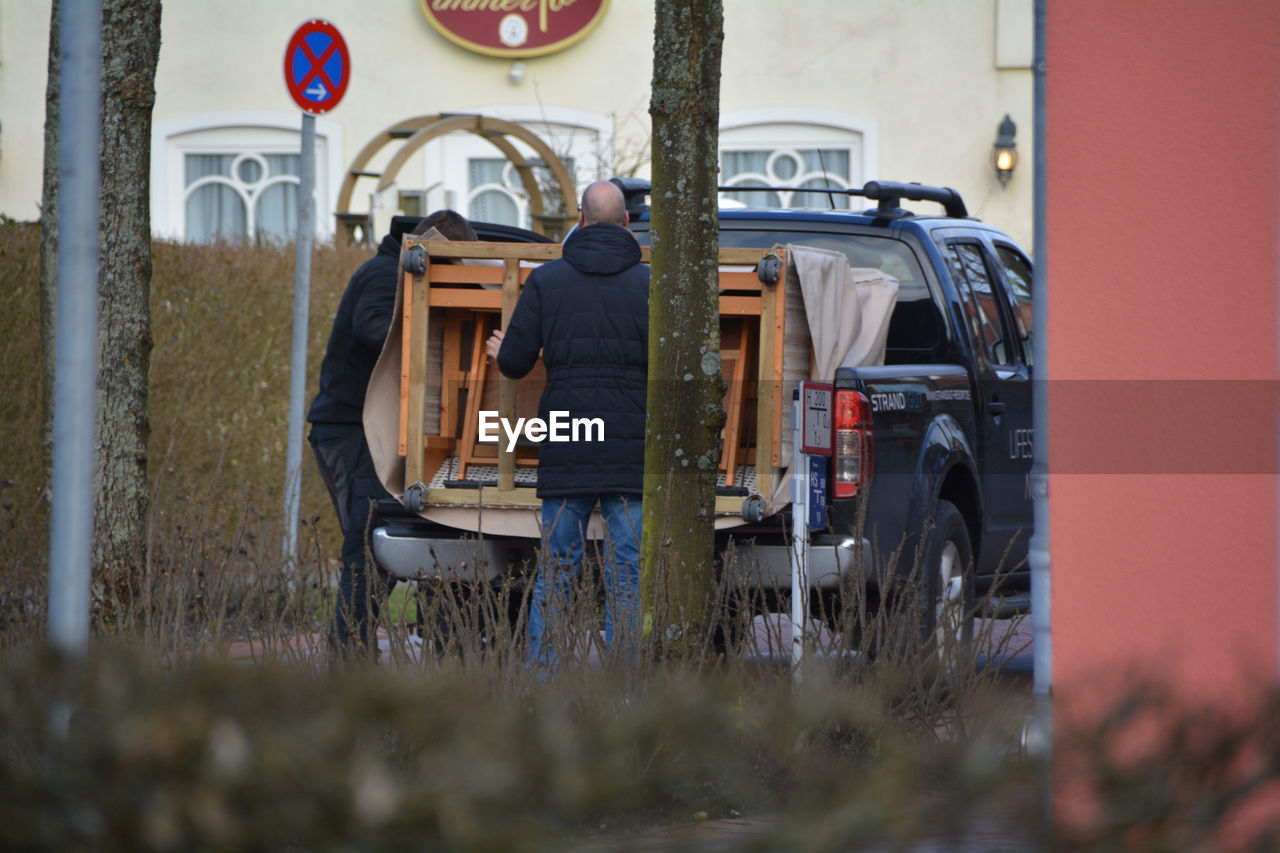 Two men putting furniture into pick-up truck