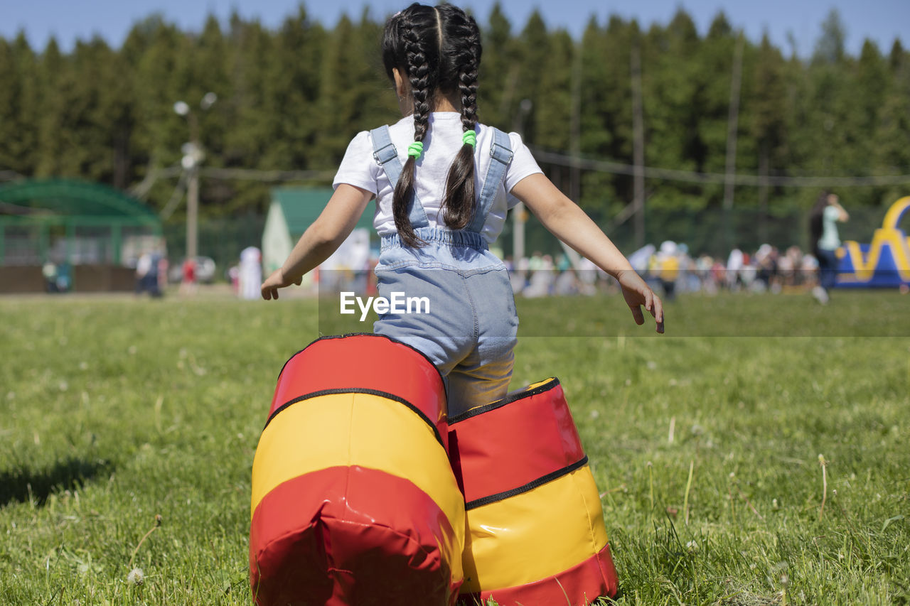 FULL LENGTH REAR VIEW OF WOMAN ON FIELD