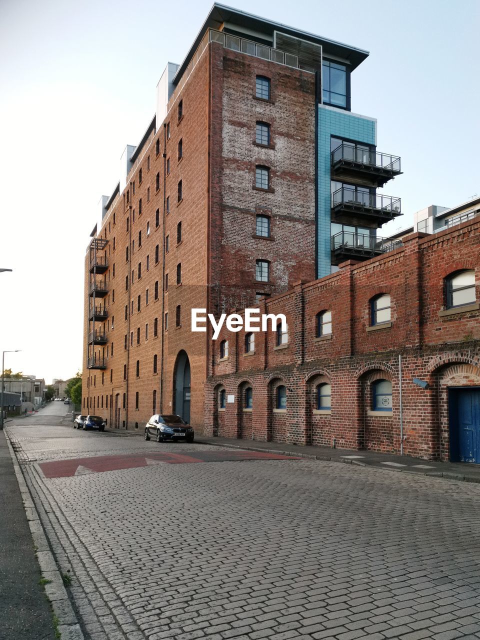 Street by buildings against sky in city