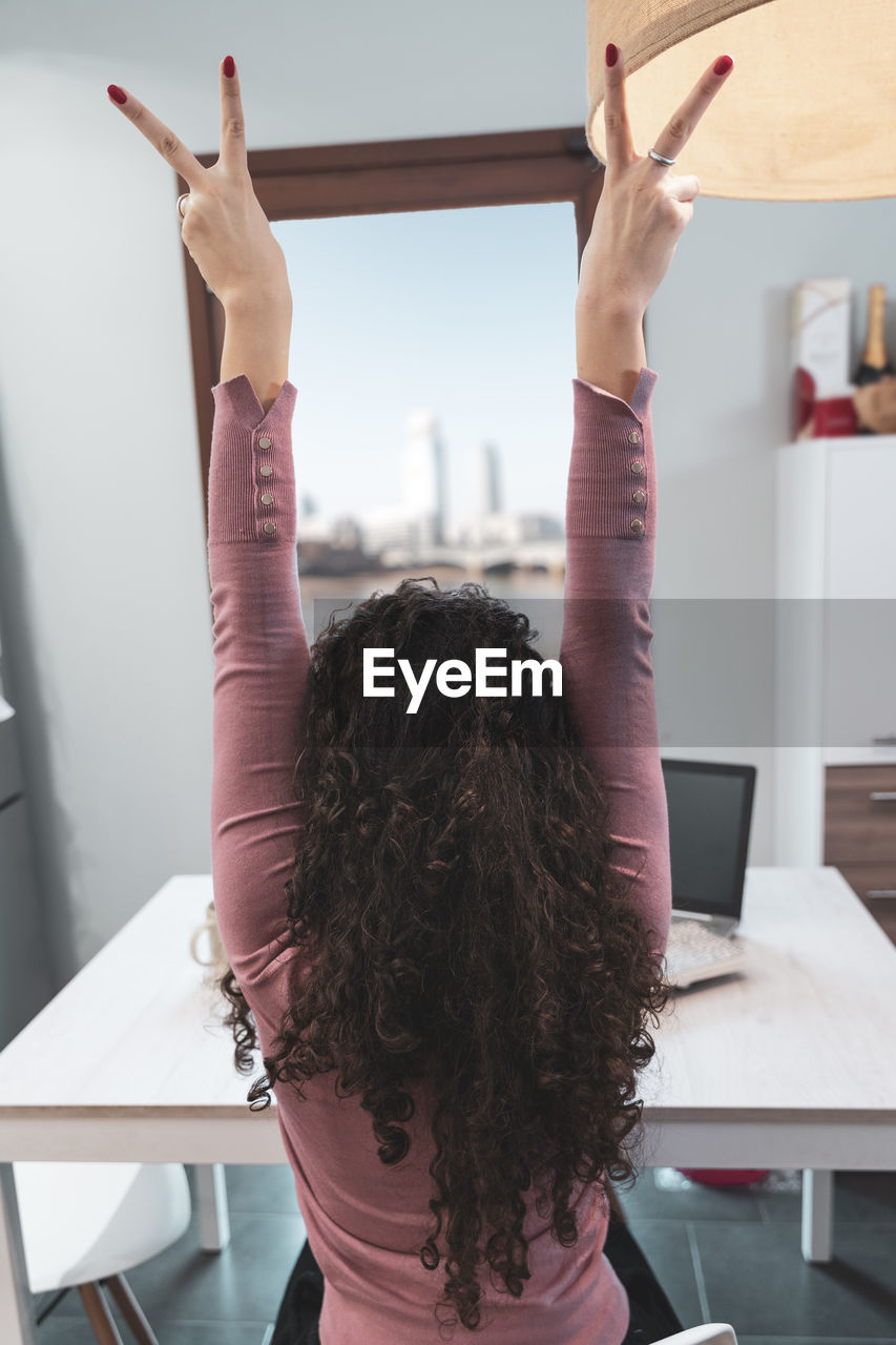 Young woman takes a relaxing moment while working at home on computer during covid-19 pandemic