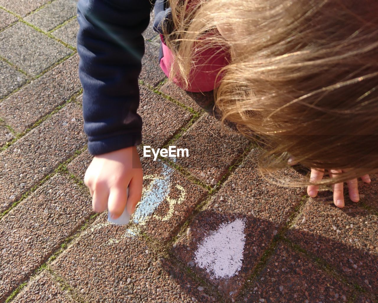 Girl drawing on footpath