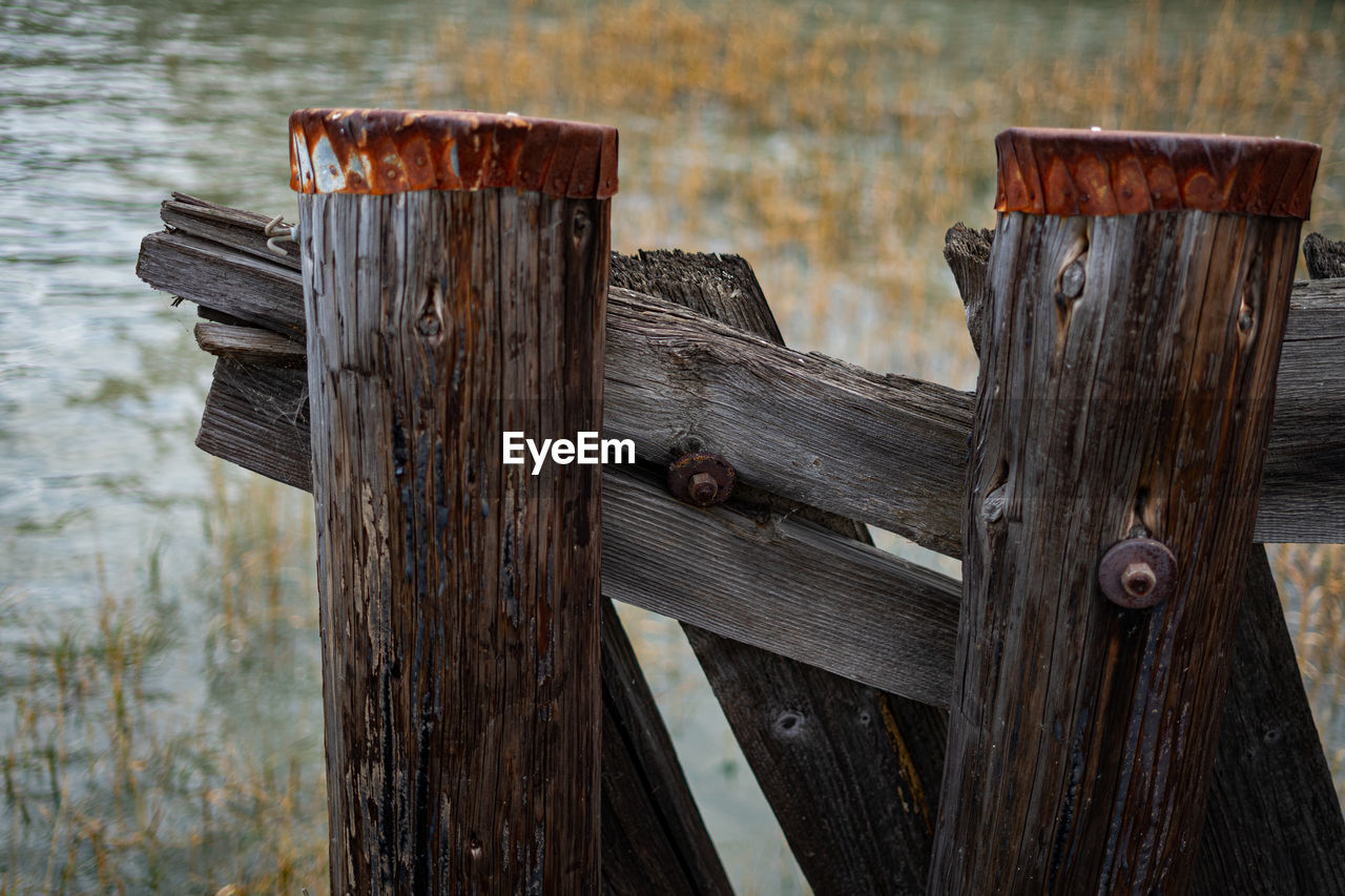 CLOSE-UP OF WOODEN POST ON FENCE