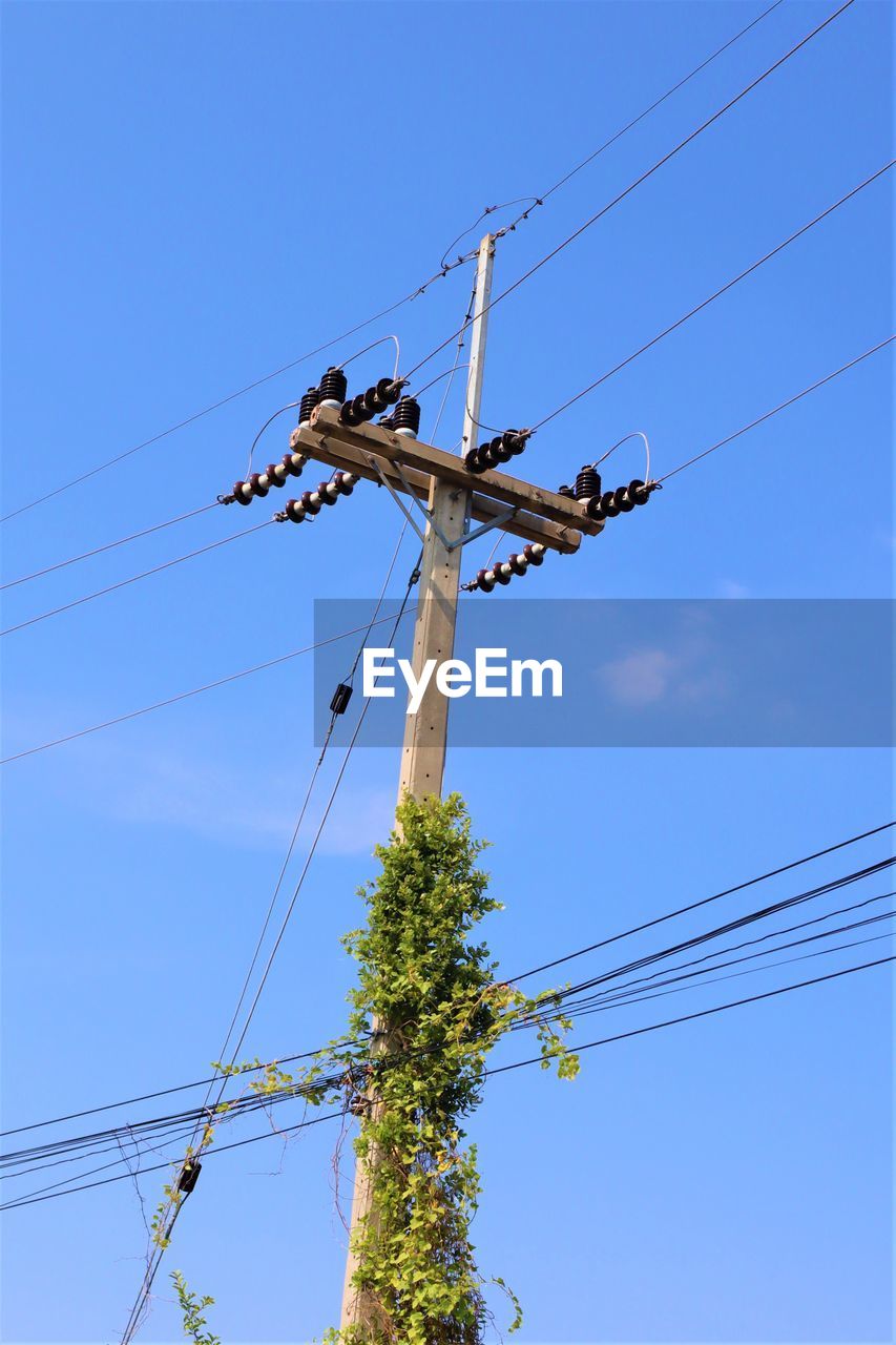 Low angle view of power line against blue sky