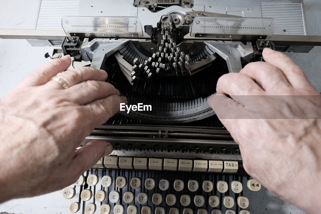 Cropped hands repairing typewriter