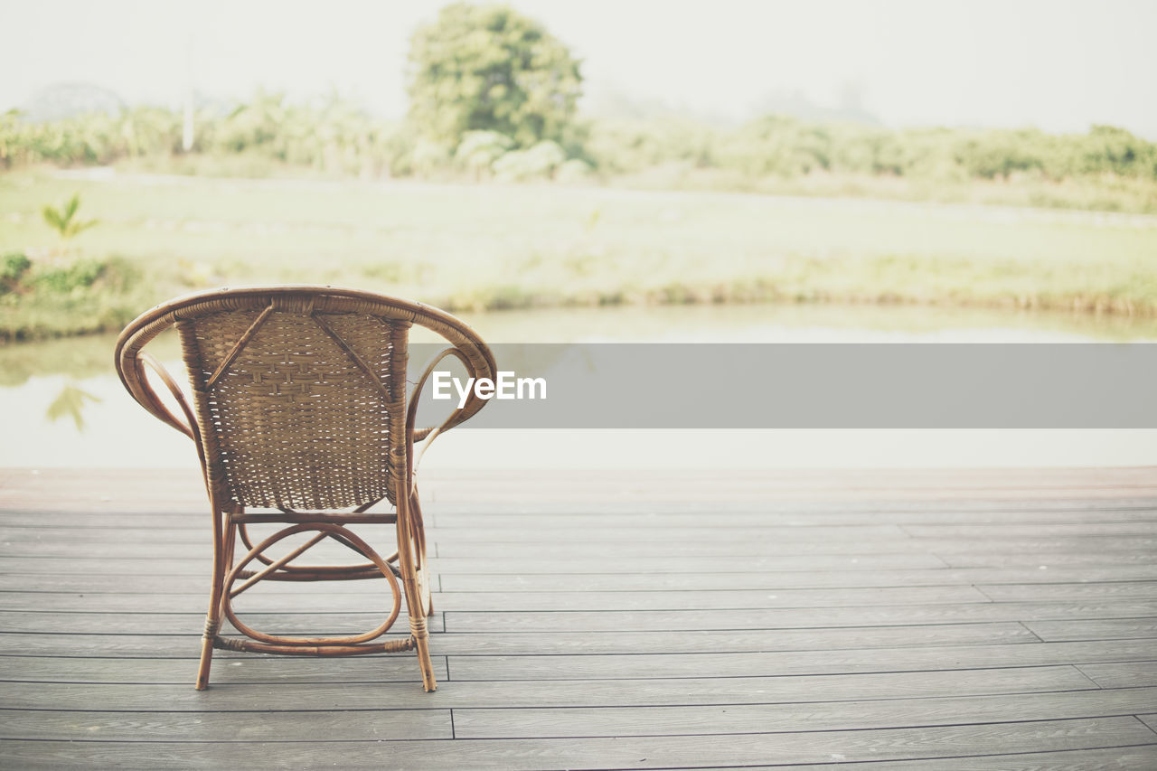 EMPTY CHAIRS AND TABLE ON BEACH