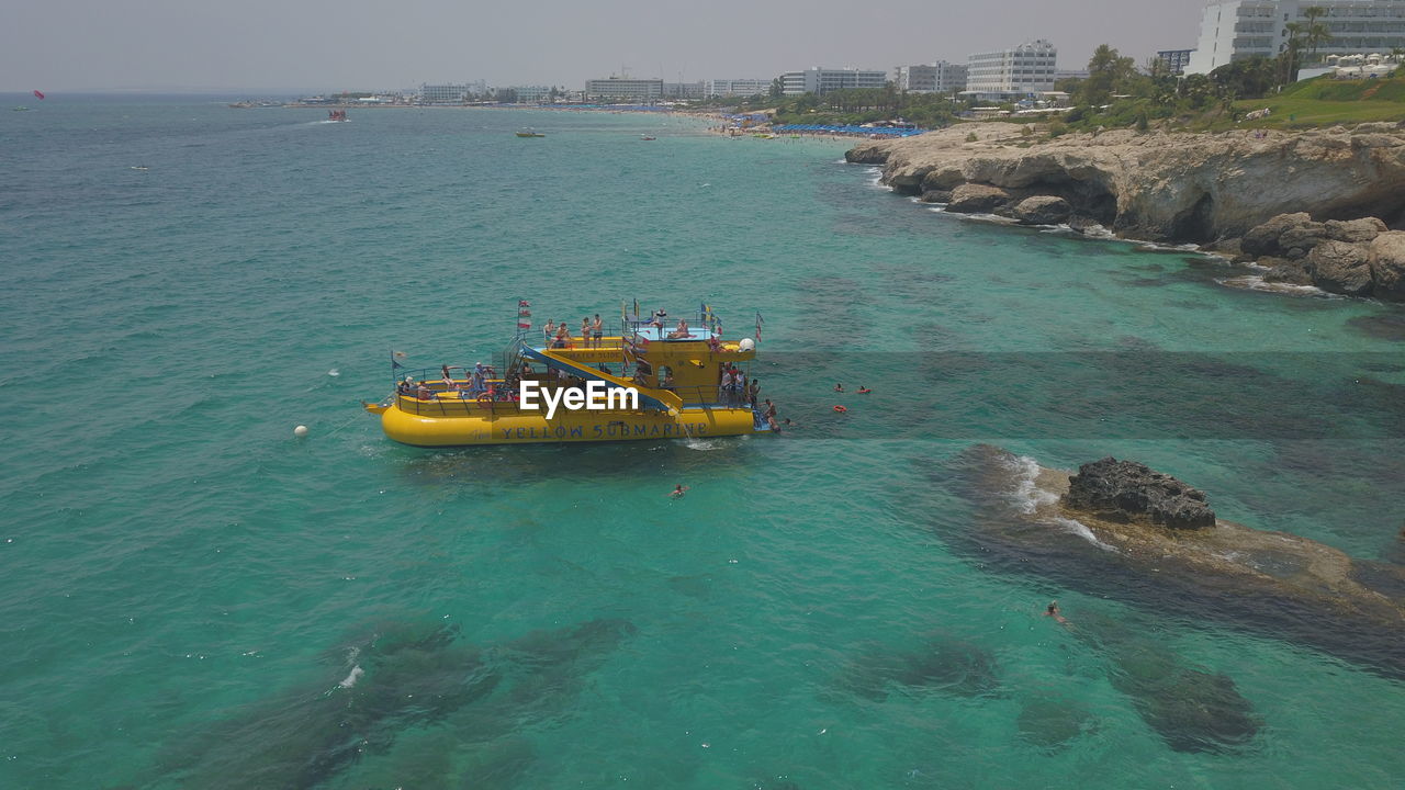 HIGH ANGLE VIEW OF BOAT SAILING IN SEA