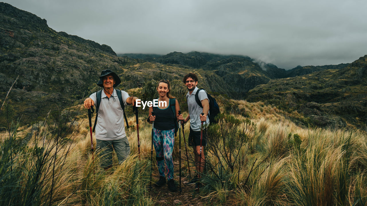 PEOPLE ON MOUNTAIN AGAINST SKY