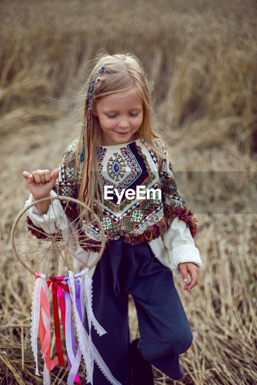 Girl indian shaman blonde in a poncho and a dream catcher