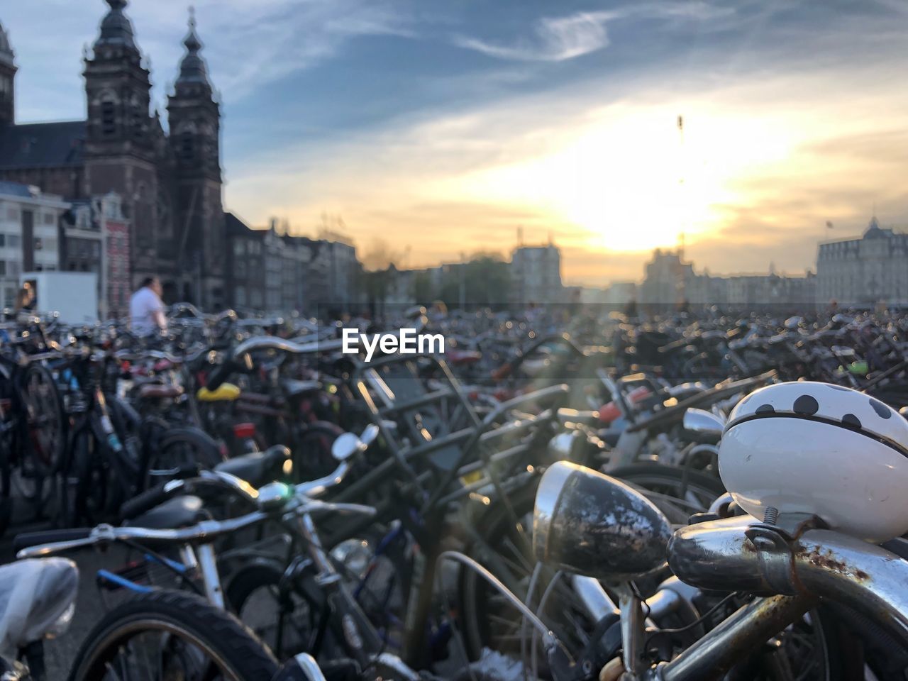 Bicycles in parking lot at city during sunset