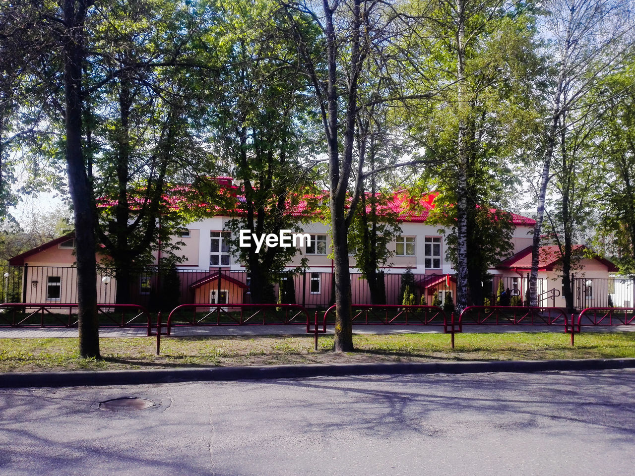 VIEW OF BUILDING WITH TREES IN FOREGROUND