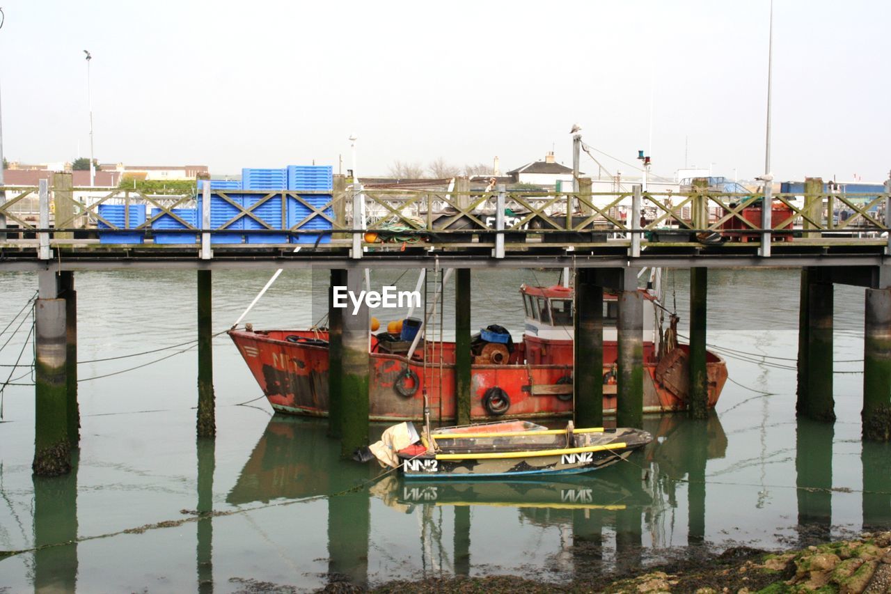 BOAT MOORED ON RIVER AGAINST SKY