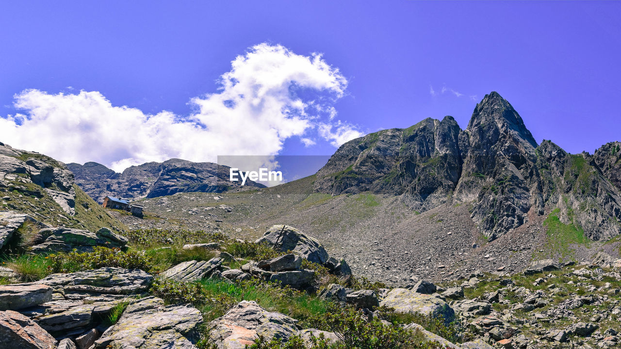 Scenic view of mountains against blue sky