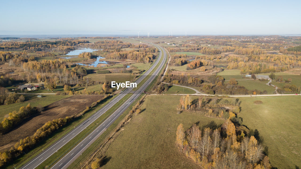 HIGH ANGLE VIEW OF ROAD PASSING THROUGH FIELD