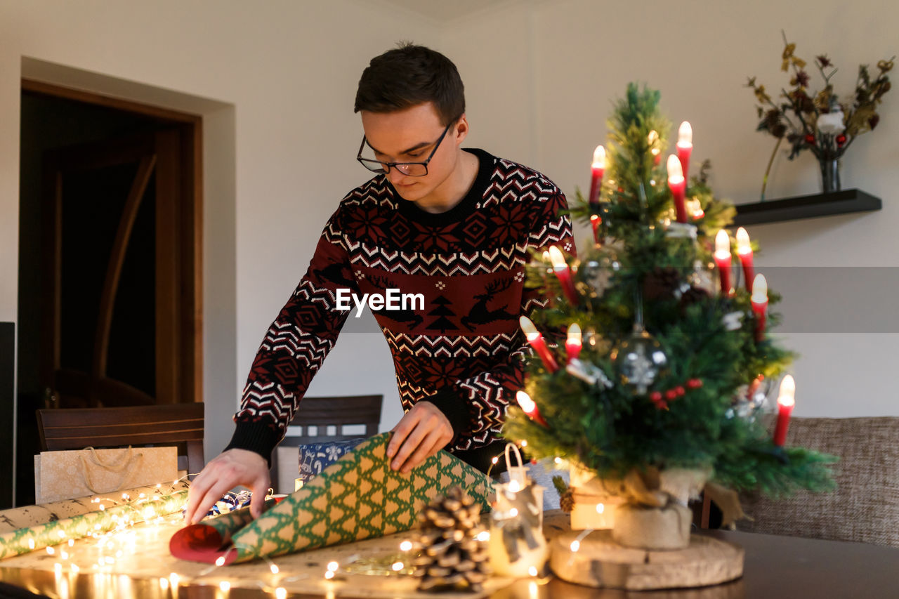 Young man packs christmas presents for friends and family