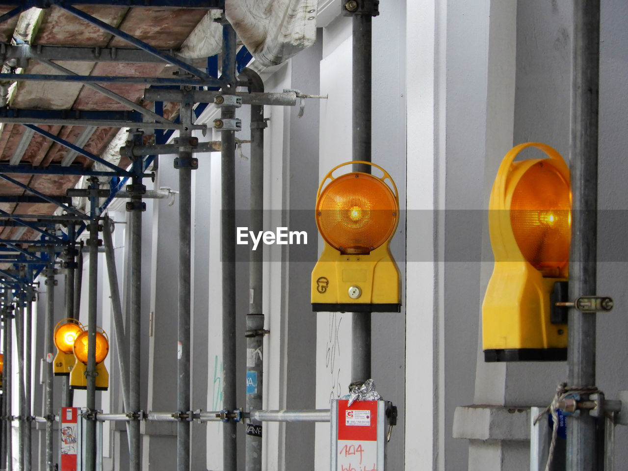 YELLOW LIGHTS HANGING FROM METAL IN FACTORY