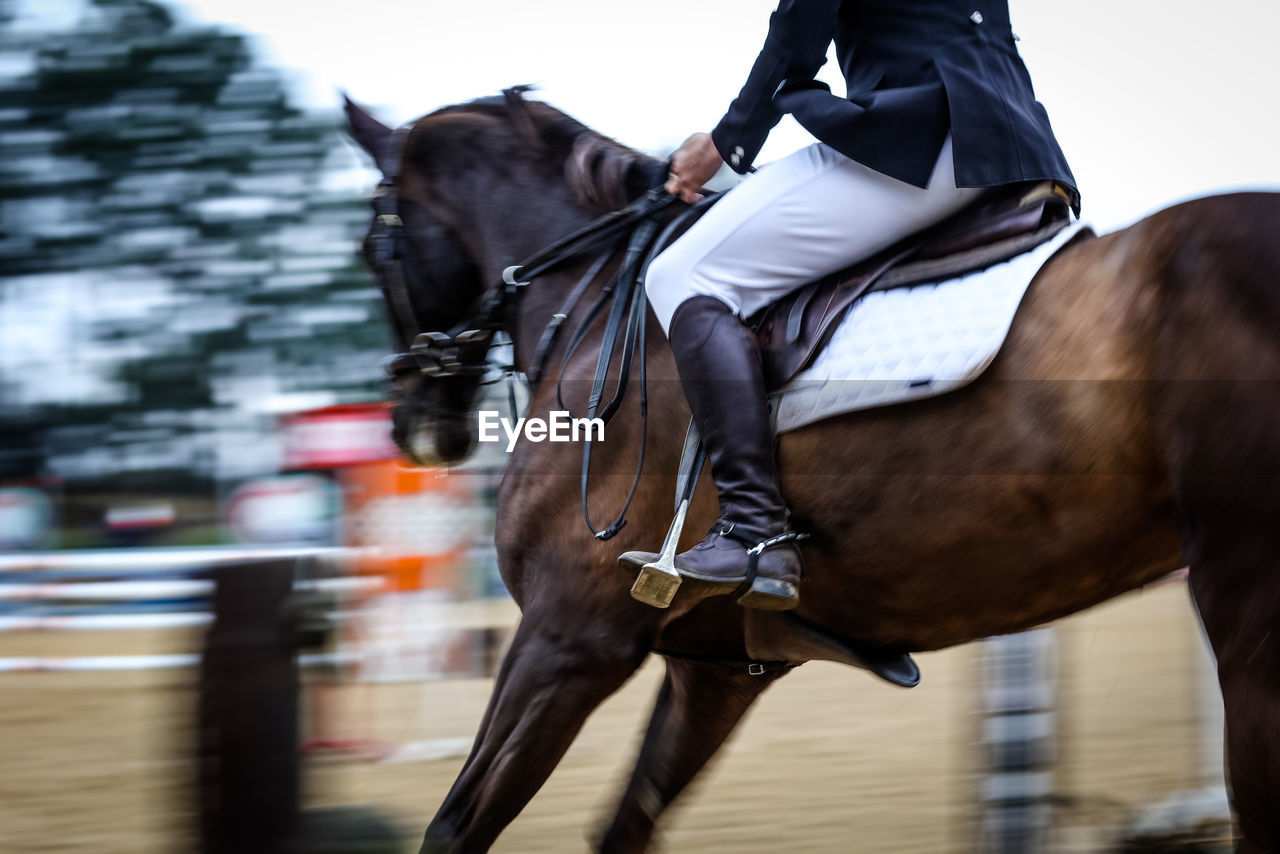 Low section of man horseback riding at equestrian event