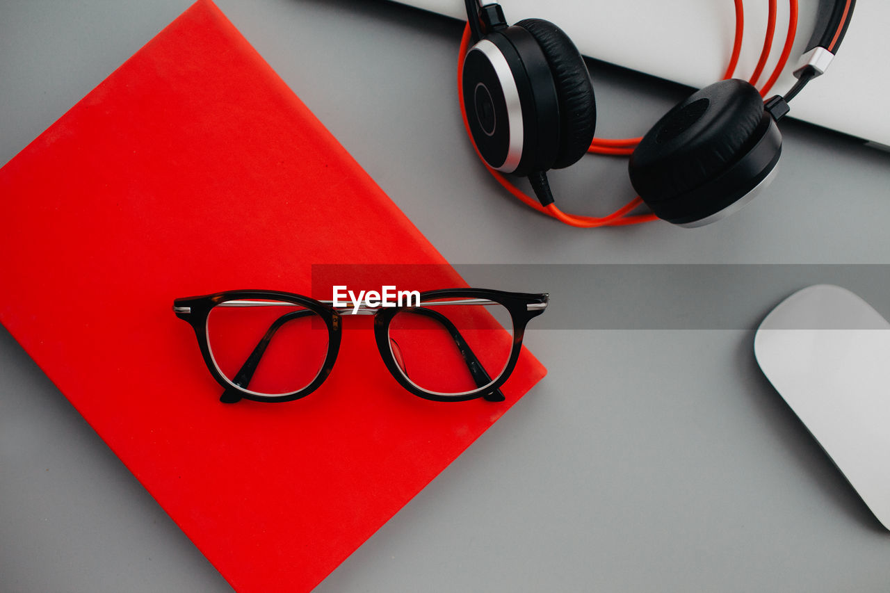 glasses, eyewear, eyeglasses, vision care, red, indoors, no people, headphones, studio shot, still life, font, technology, high angle view, sunglasses, close-up, fashion, communication, black