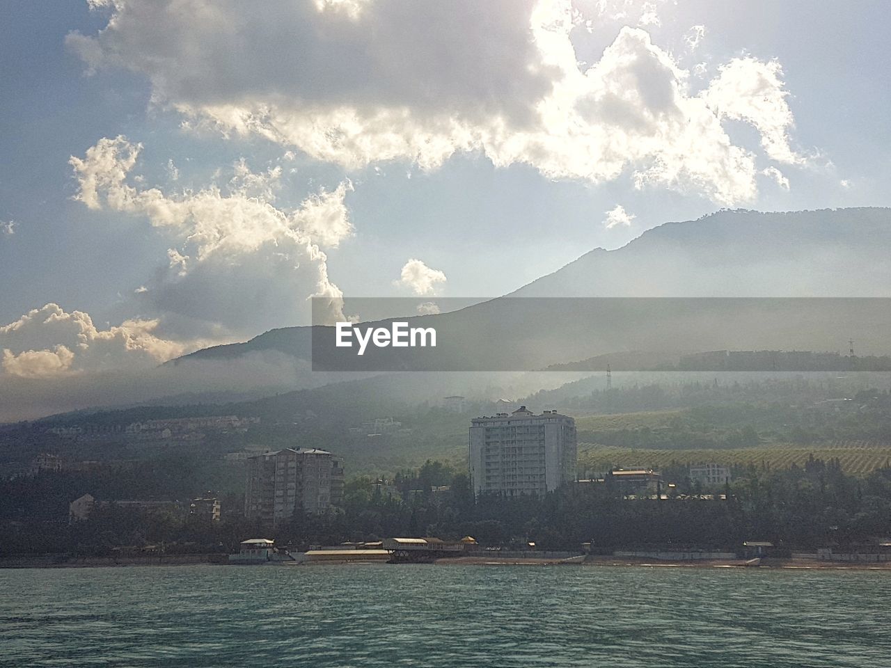 SEA BY BUILDINGS AGAINST SKY