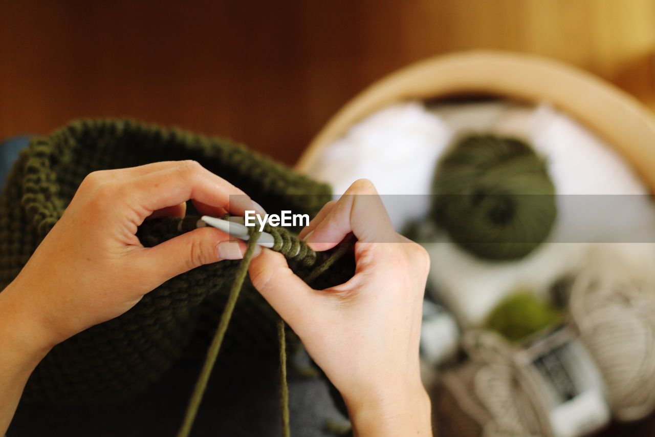 Cropped hands of woman knitting wool