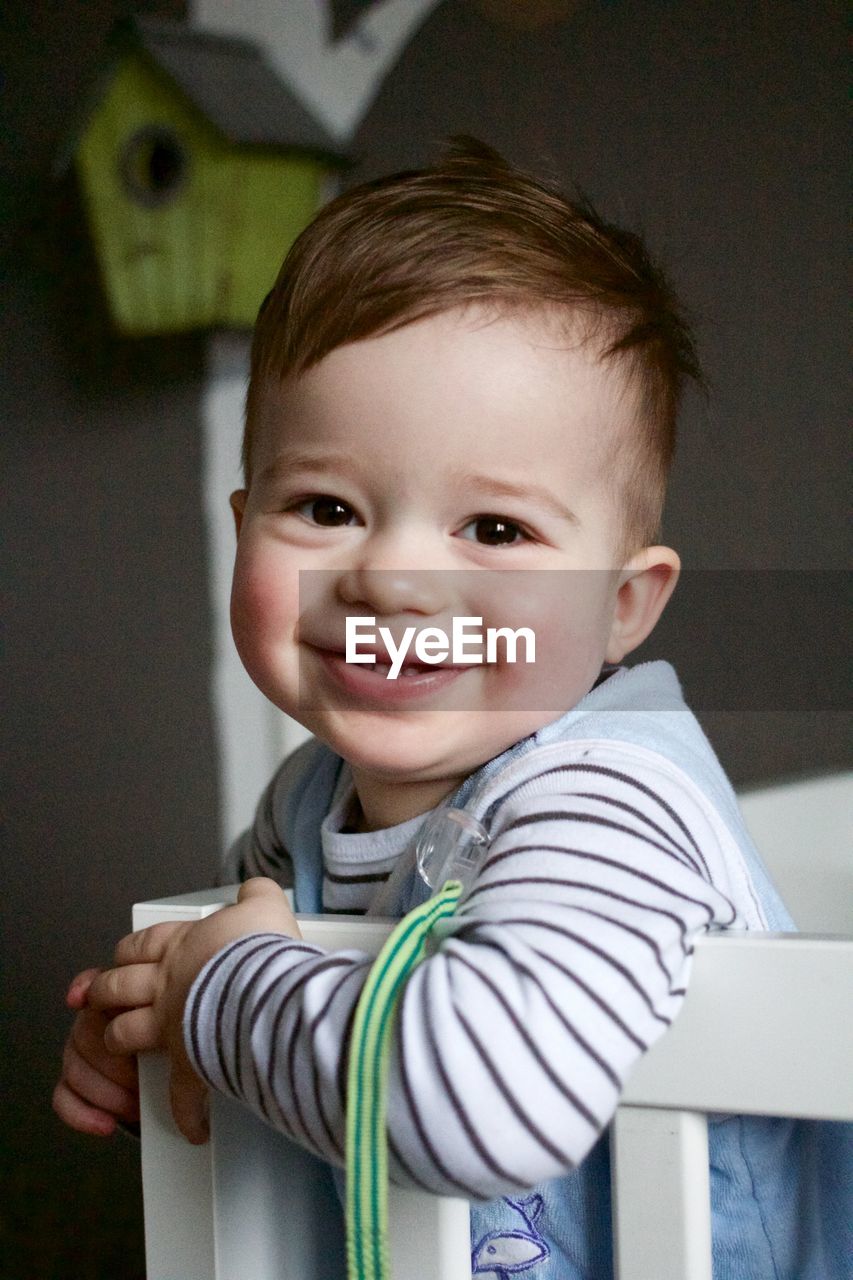 Close-up portrait of cute boy in crib