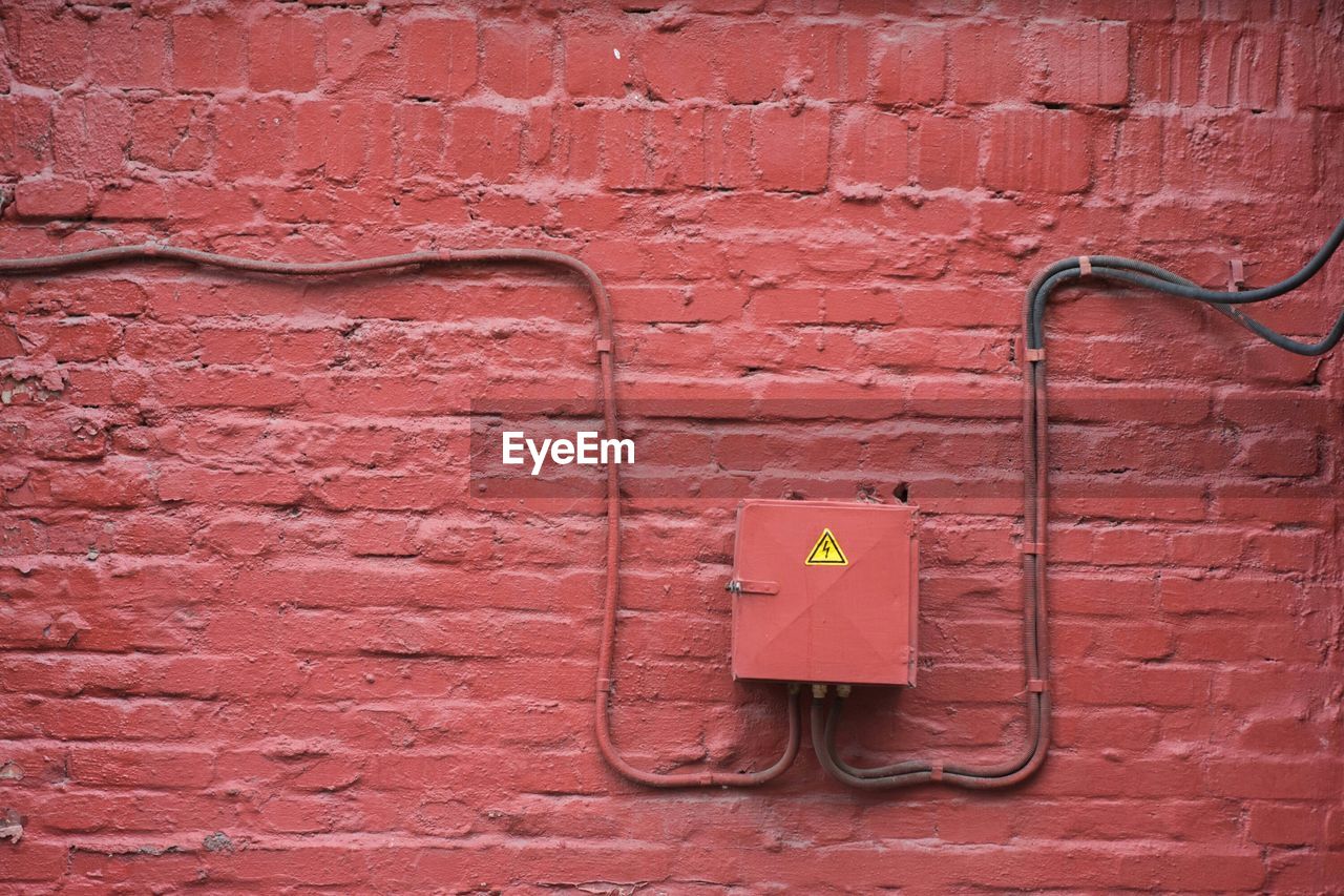 Close-up of meter box on red wall
