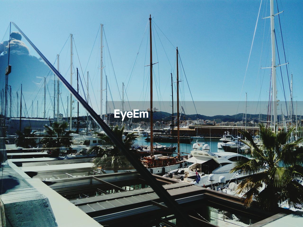 SAILBOATS MOORED AT HARBOR