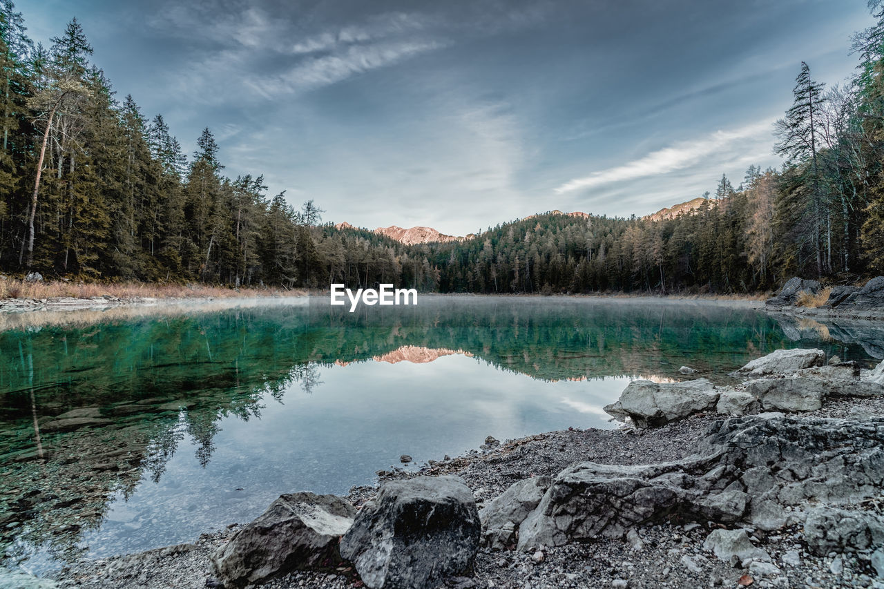 Scenic view of lake in forest against sky