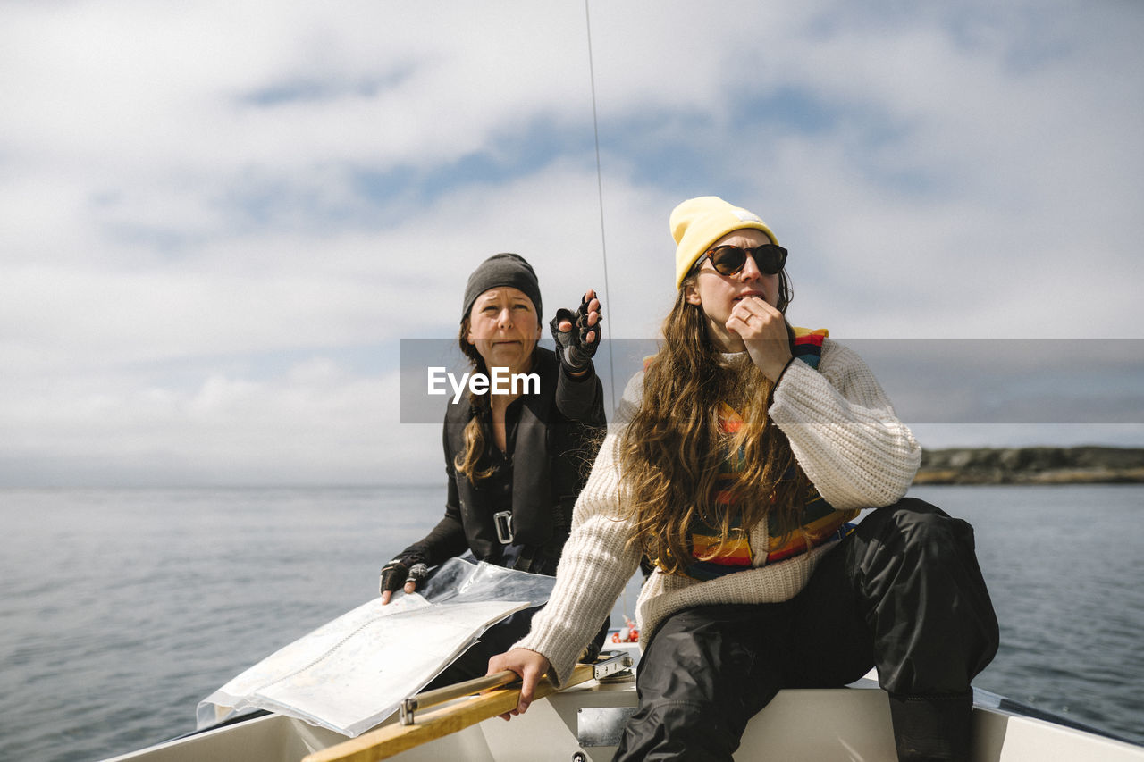 Women sitting on boat and using map to set direction