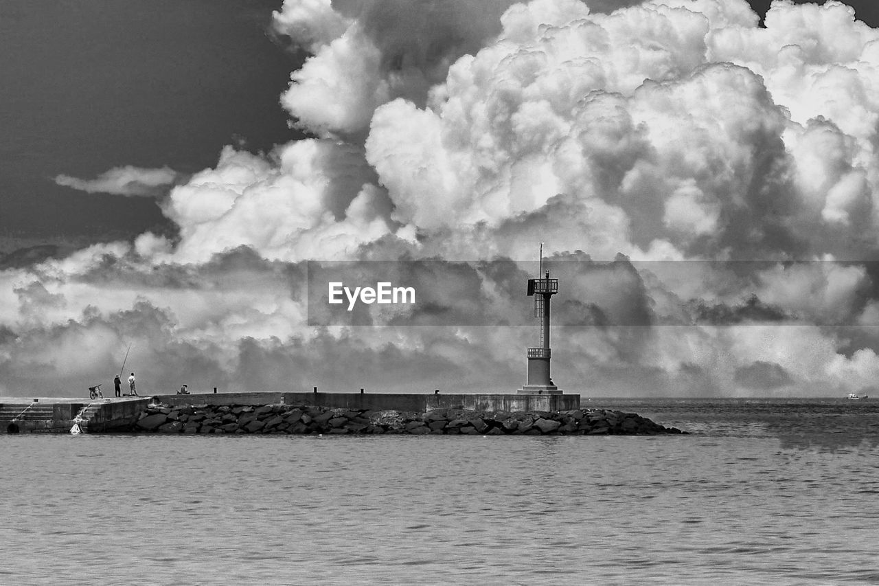 Lighthouse by sea against sky