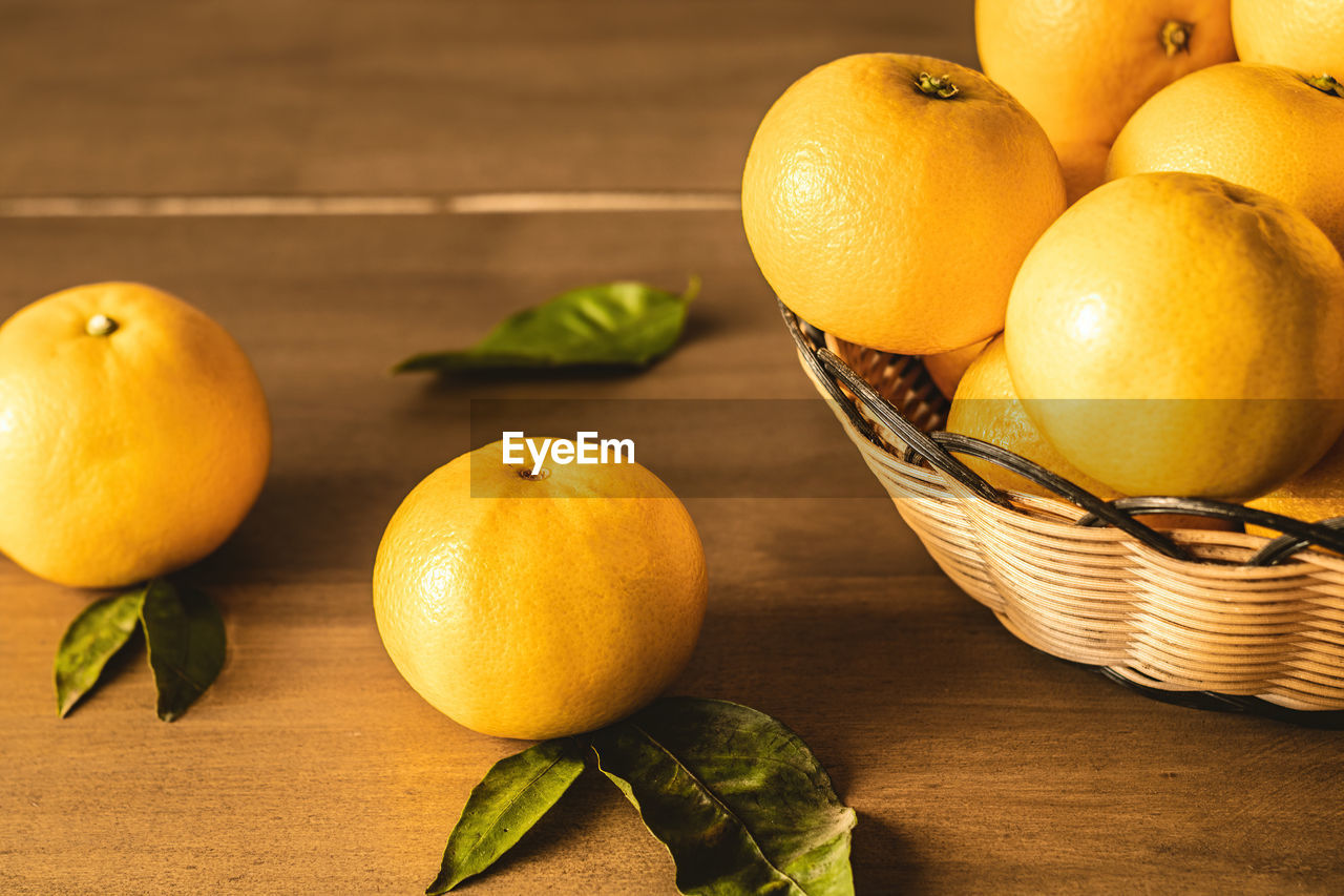 CLOSE-UP OF ORANGE FRUITS ON TABLE