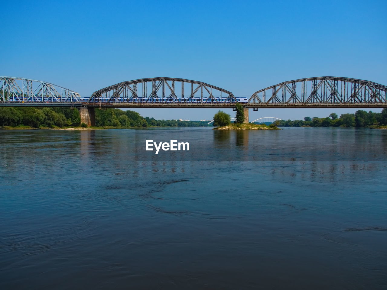 BRIDGE OVER RIVER AGAINST BLUE SKY