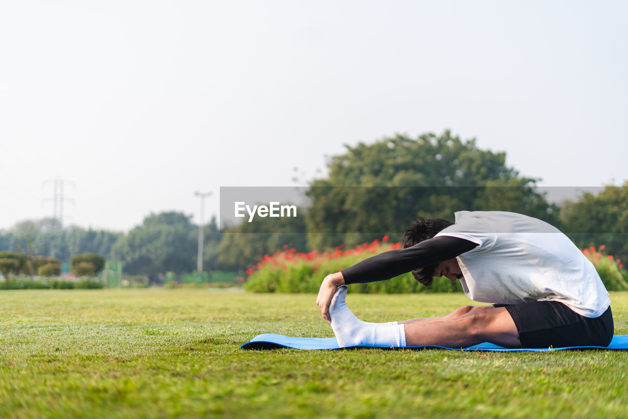 low section of woman exercising on field