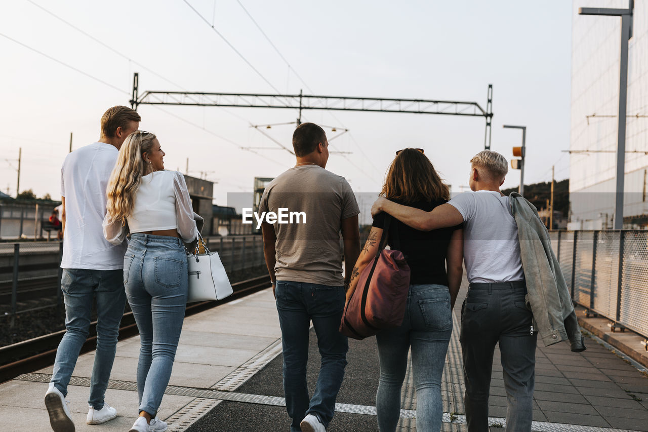 Rear view of young friends walking together