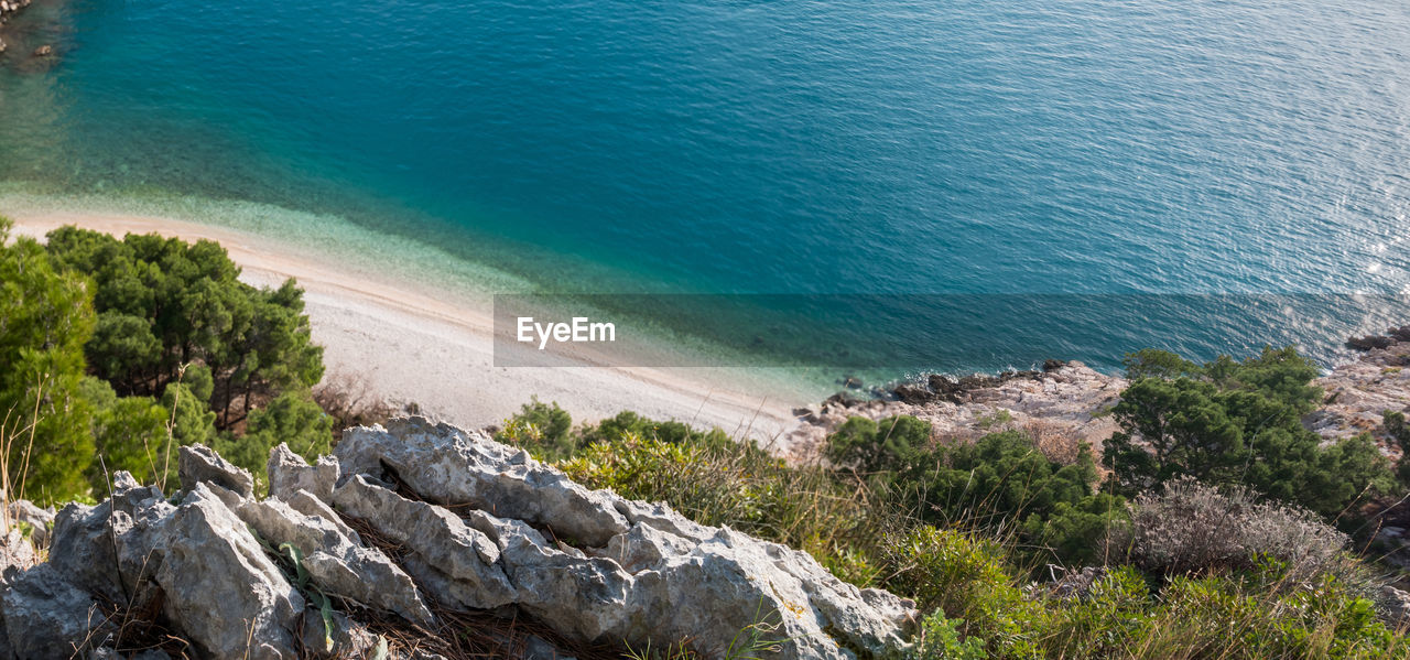 HIGH ANGLE VIEW OF ROCKS ON SHORE