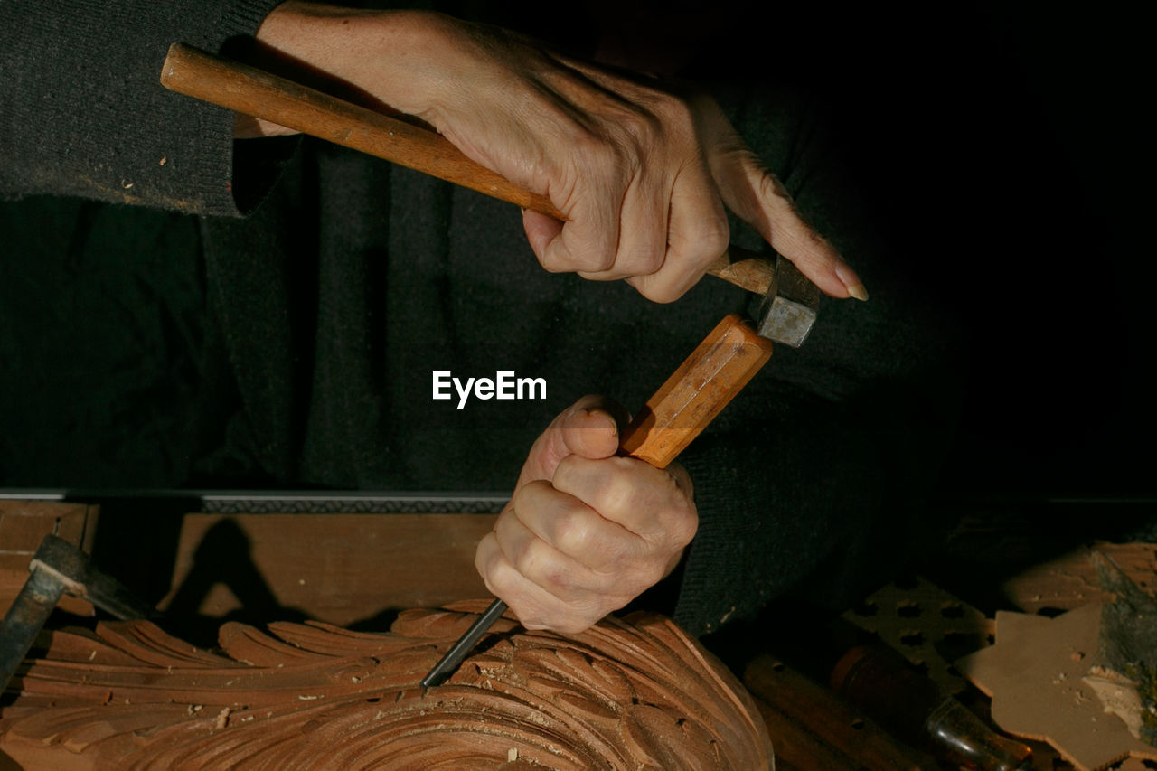 Craftsman's hands working on wood carving, with gouge and chisel cabinetmaker, carpentry