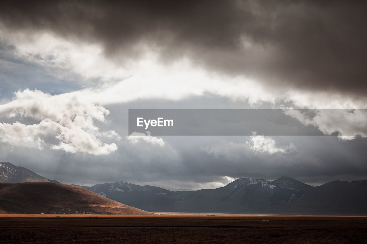 Scenic view of mountain against cloudy sky