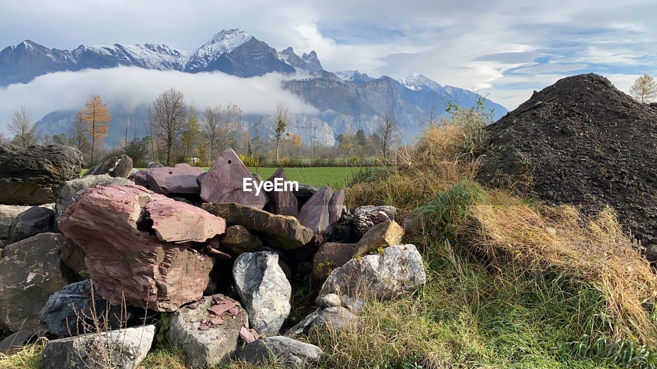 STACK OF ROCKS AND PLANTS AGAINST SKY